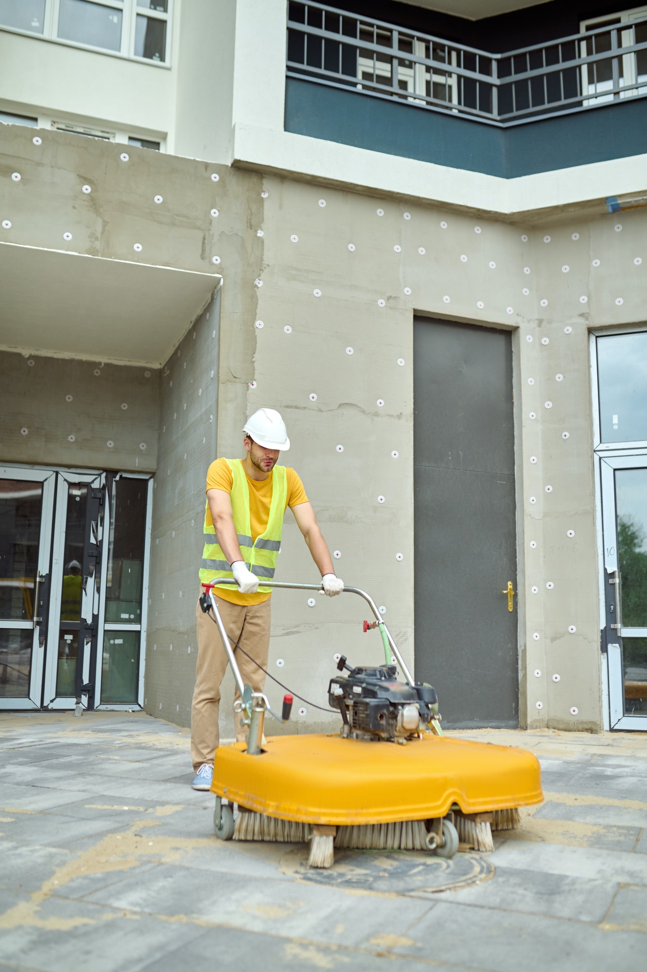 Man operating special equipment cleaning construction site